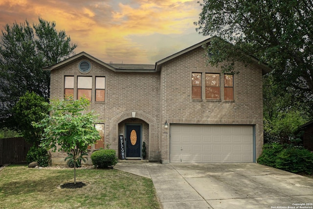 traditional-style home featuring fence, an attached garage, brick siding, a front yard, and driveway