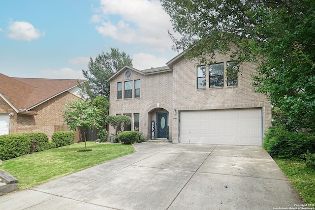 traditional-style home featuring brick siding, driveway, a front yard, and a garage