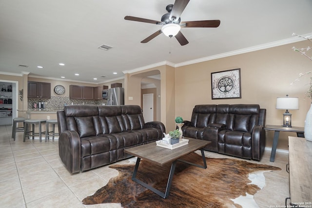 living area with a ceiling fan, visible vents, ornamental molding, and light tile patterned floors