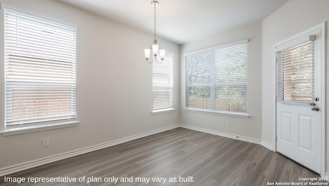 21031 Millstream Bnd, San Antonio, TX 78266 - unfurnished dining area featuring baseboards, wood finished floors, and a chandelier