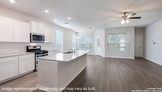 21031 Millstream Bnd, San Antonio, TX 78266 - kitchen with white cabinets, appliances with stainless steel finishes, a sink, a ceiling fan, and wood finished floors