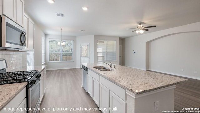 21031 Millstream Bnd, San Antonio, TX 78266 - kitchen featuring ceiling fan with notable chandelier, baseboards, light wood-type flooring, a sink, and appliances with stainless steel finishes