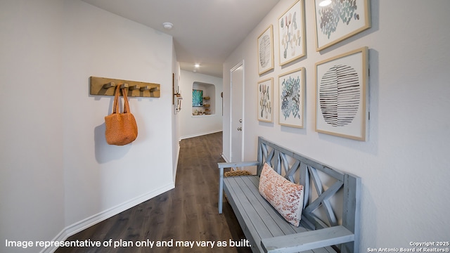 corridor featuring baseboards and wood finished floors