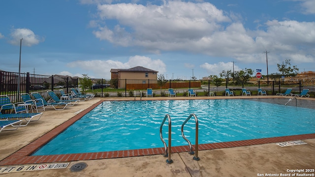 pool with a patio area and fence