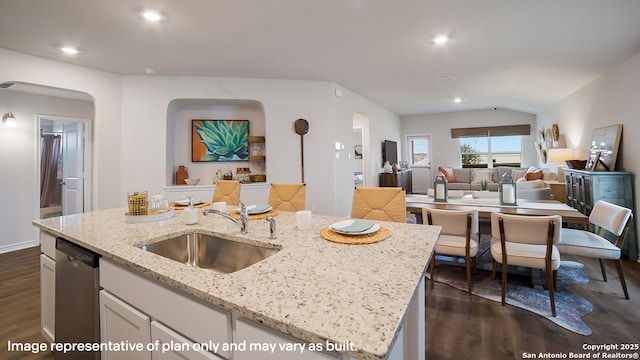 kitchen featuring stainless steel dishwasher, open floor plan, a sink, and dark wood-type flooring