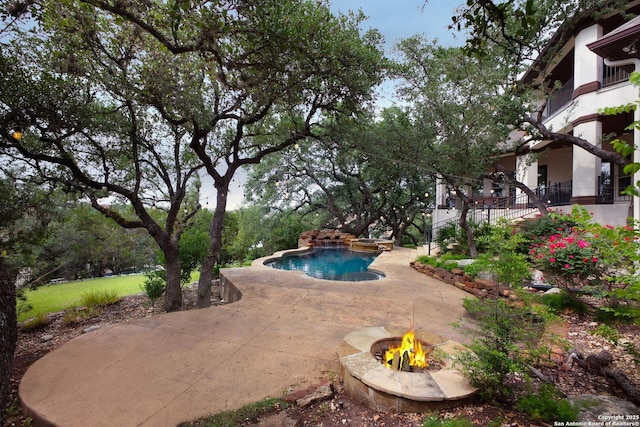 outdoor pool featuring a patio, an outdoor fire pit, and an outdoor hot tub