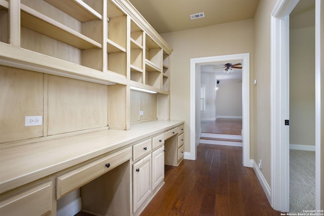 corridor featuring dark wood-style flooring, baseboards, and visible vents