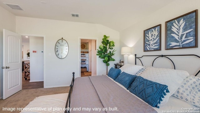 carpeted bedroom with visible vents, baseboards, a spacious closet, and vaulted ceiling