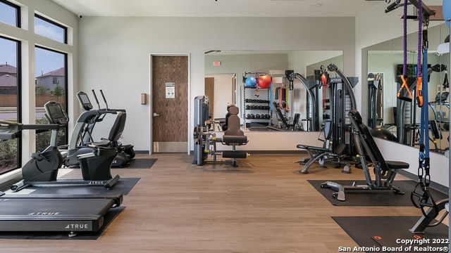 workout area featuring baseboards and wood finished floors