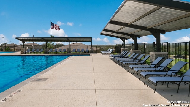 community pool featuring fence and a patio area