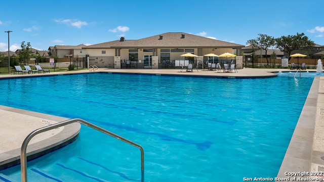pool with a patio and fence