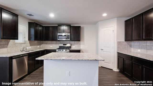14610 Clay Ridge Run, San Antonio, TX 78253 - kitchen with visible vents, dark wood-type flooring, a sink, appliances with stainless steel finishes, and backsplash