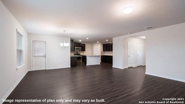 14610 Clay Ridge Run, San Antonio, TX 78253 - unfurnished living room with dark wood-style flooring, baseboards, a chandelier, and arched walkways