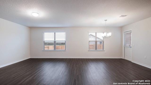 14610 Clay Ridge Run, San Antonio, TX 78253 - spare room featuring dark wood-style flooring, baseboards, a chandelier, and plenty of natural light