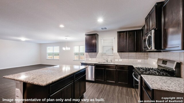 14610 Clay Ridge Run, San Antonio, TX 78253 - kitchen featuring dark wood-style flooring, visible vents, appliances with stainless steel finishes, tasteful backsplash, and an inviting chandelier