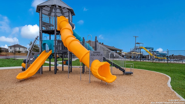 communal playground with a yard and fence