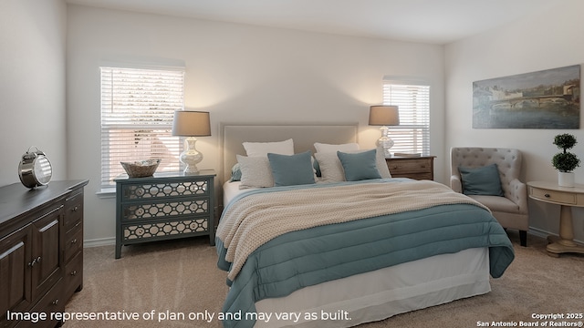 bedroom with light colored carpet and baseboards