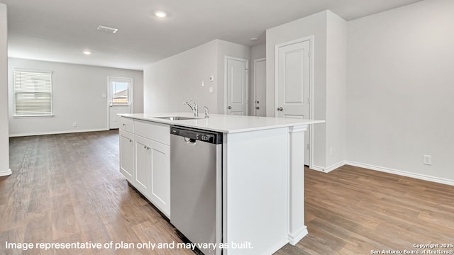 kitchen with a sink, baseboards, stainless steel dishwasher, and white cabinetry