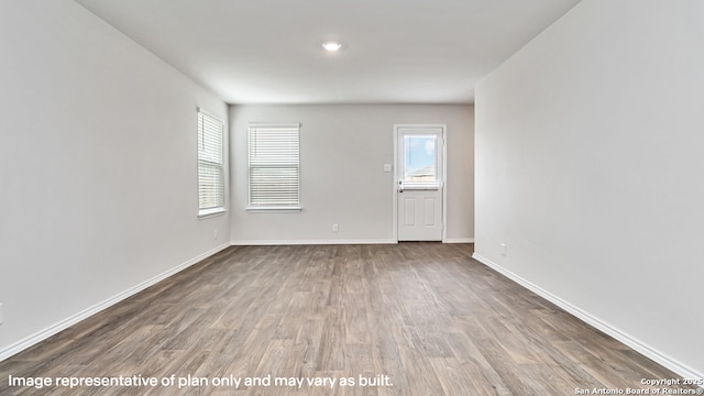 unfurnished room with baseboards and wood finished floors