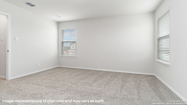 spare room with carpet flooring, baseboards, and visible vents