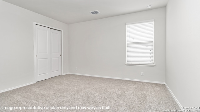 carpeted empty room featuring baseboards and visible vents