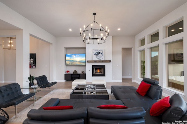 living area with an inviting chandelier, baseboards, recessed lighting, and wood finished floors