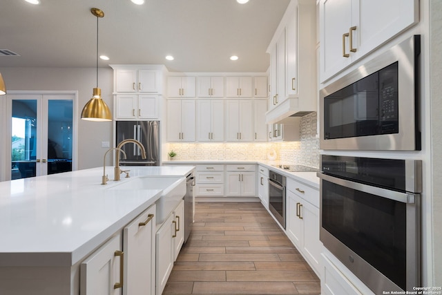kitchen featuring light countertops, appliances with stainless steel finishes, recessed lighting, and wood finished floors