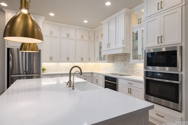 kitchen with a sink, light countertops, stainless steel appliances, recessed lighting, and backsplash