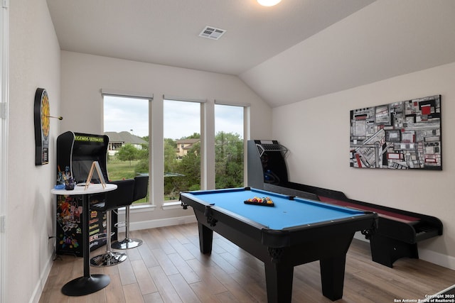 rec room featuring visible vents, baseboards, wood finished floors, and vaulted ceiling