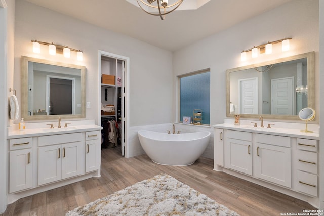 bathroom featuring a sink, wood finished floors, and two vanities