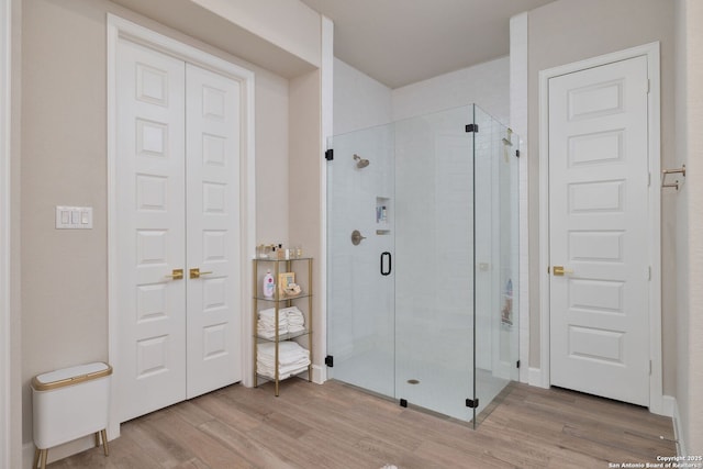 bathroom with wood finished floors and a stall shower