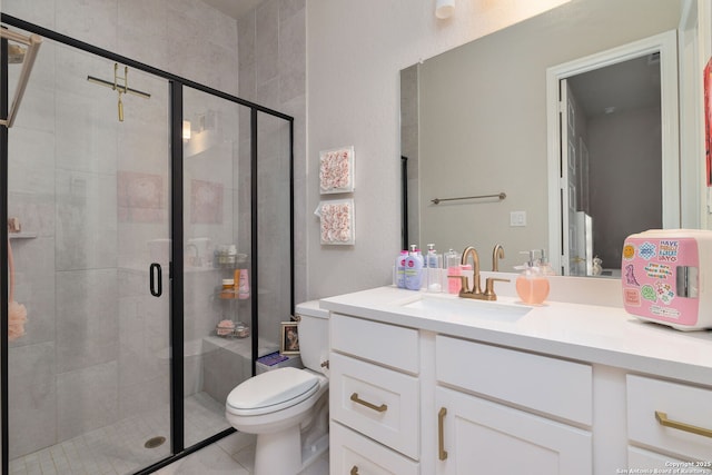 bathroom featuring vanity, tile patterned floors, a stall shower, and toilet