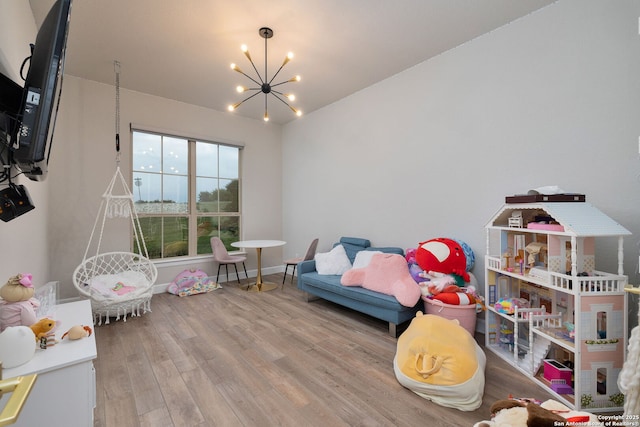 recreation room with an inviting chandelier, baseboards, and wood finished floors