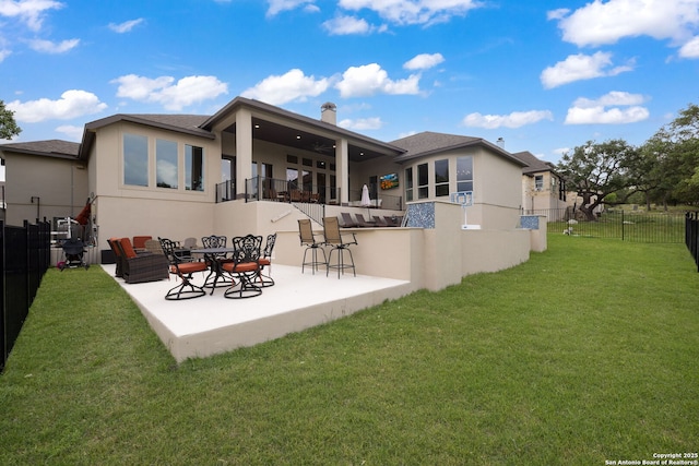 rear view of property featuring a fenced backyard, stucco siding, a chimney, a patio area, and a lawn