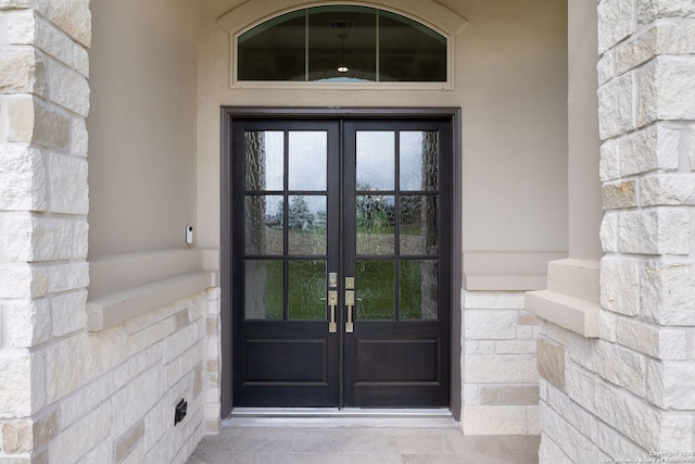 doorway to property featuring french doors and stone siding