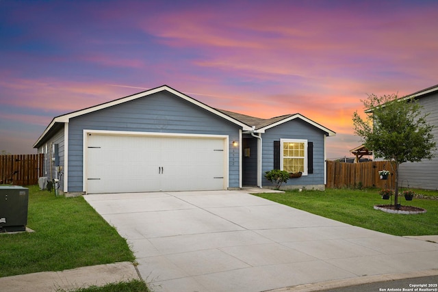 ranch-style home with an attached garage, fence, driveway, and a front yard