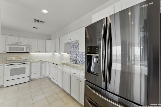 kitchen with white appliances, visible vents, a sink, and light countertops