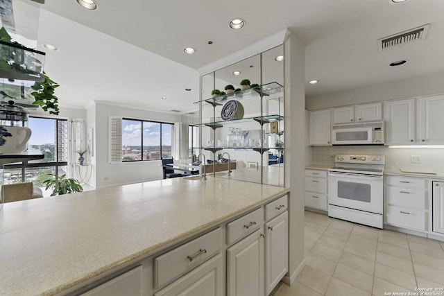 kitchen with visible vents, decorative backsplash, white appliances, white cabinetry, and light tile patterned floors