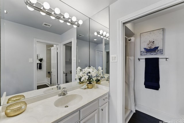 full bathroom featuring vanity, baseboards, a shower with curtain, and visible vents