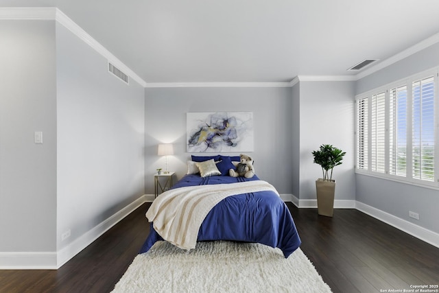 bedroom with crown molding, baseboards, visible vents, and wood finished floors