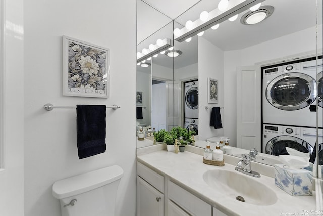 bathroom featuring vanity, stacked washing maching and dryer, and toilet