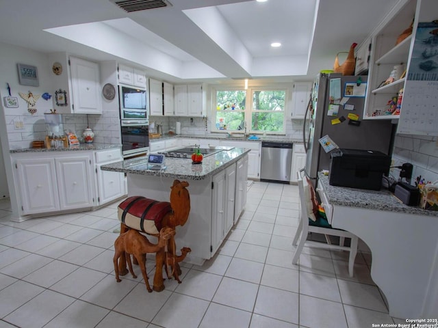 11402 Mission Trace St, San Antonio, TX 78230 - kitchen featuring backsplash, appliances with stainless steel finishes, light tile patterned floors, a raised ceiling, and white cabinetry