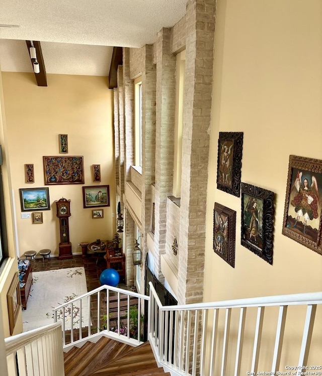 11402 Mission Trace St, San Antonio, TX 78230 - stairway with a fireplace, beamed ceiling, and a textured ceiling