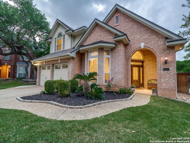 view of front of home with brick siding, a front lawn, an attached garage, and concrete driveway