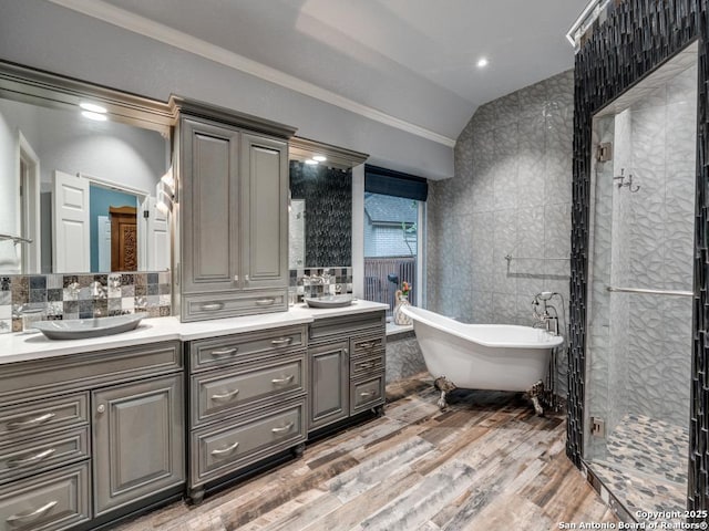 full bath with a sink, tile walls, double vanity, and lofted ceiling