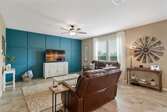 27342 Emilie Cyn, San Antonio, TX 78260 - living area with visible vents, a ceiling fan, an accent wall, and a decorative wall