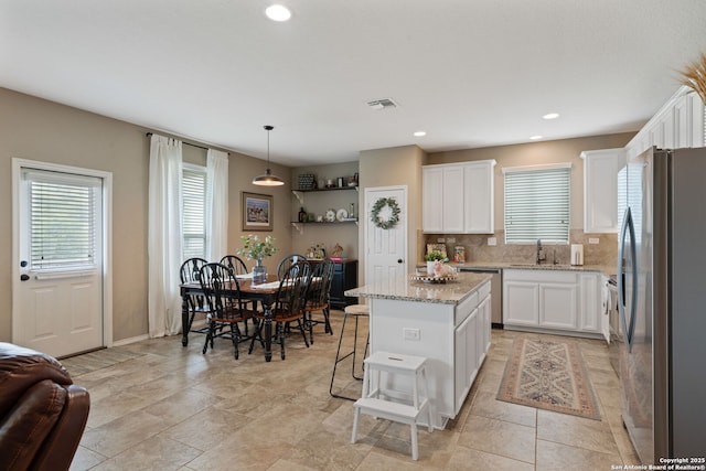 27342 Emilie Cyn, San Antonio, TX 78260 - kitchen featuring appliances with stainless steel finishes, white cabinets, a center island, and visible vents