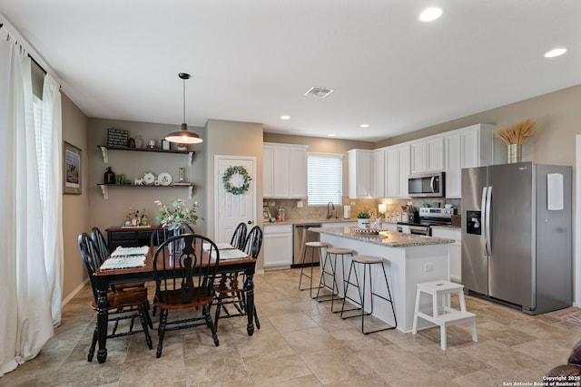 27342 Emilie Cyn, San Antonio, TX 78260 - kitchen with white cabinets, a sink, stainless steel appliances, decorative backsplash, and a kitchen island