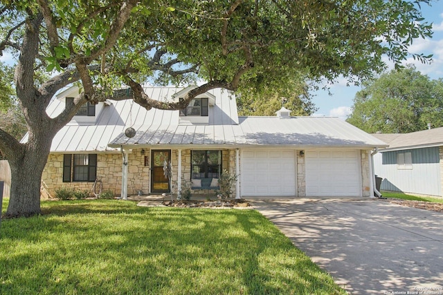 view of front of home with a standing seam roof, driveway, a front yard, an attached garage, and stone siding