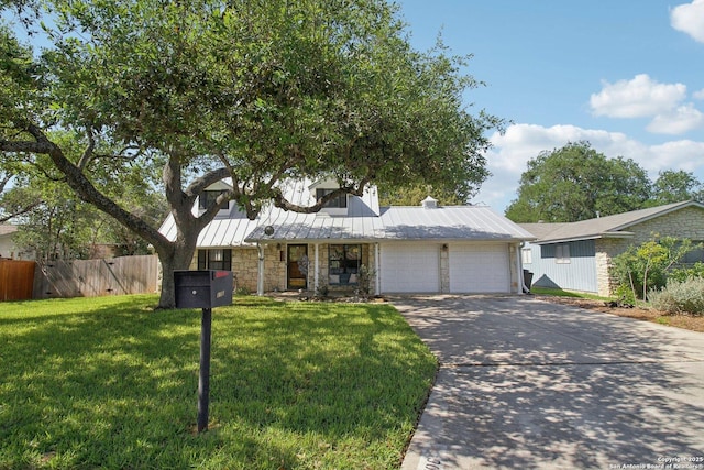 view of front of home with fence, an attached garage, stone siding, a front yard, and concrete driveway
